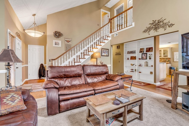 living room featuring high vaulted ceiling and light hardwood / wood-style floors