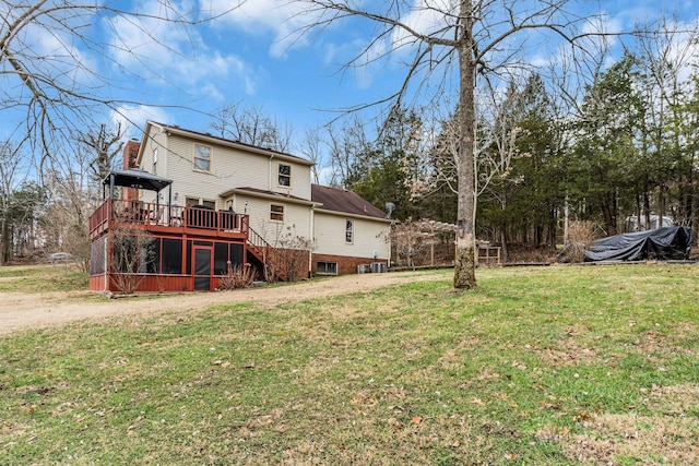 rear view of house with a lawn and a wooden deck