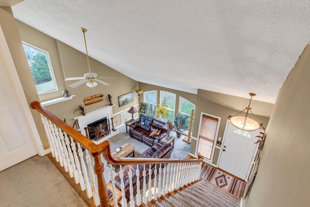 carpeted living room featuring a wealth of natural light, ceiling fan, a textured ceiling, and high vaulted ceiling