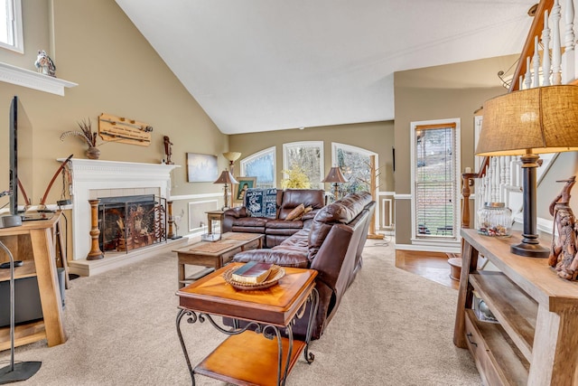 carpeted living room featuring a tiled fireplace, a wealth of natural light, and vaulted ceiling