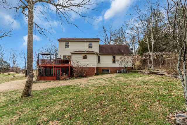 back of house with a yard, a sunroom, and a wooden deck