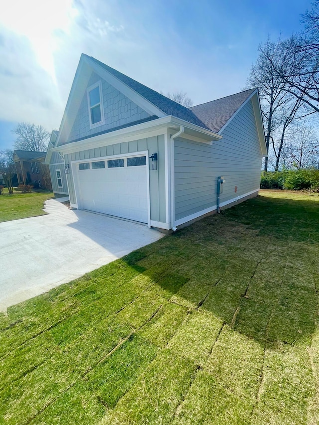 view of home's exterior featuring a yard, a shingled roof, concrete driveway, a garage, and board and batten siding