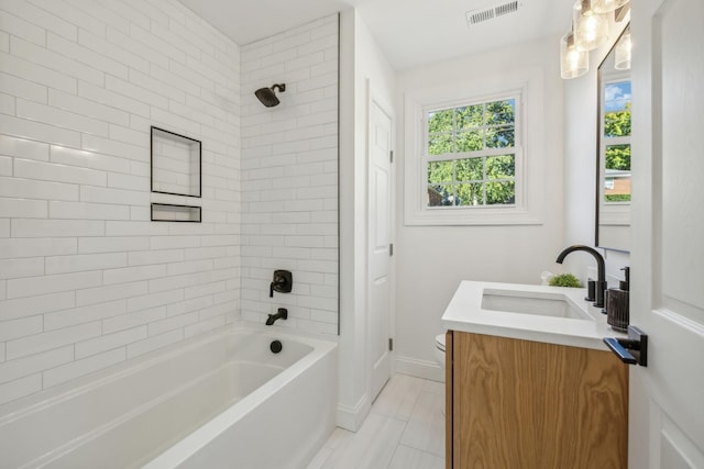 full bathroom featuring tile patterned flooring, vanity, toilet, and tiled shower / bath combo