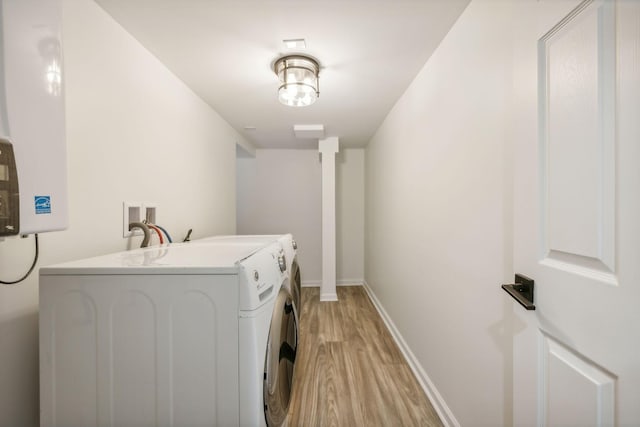 laundry area with light wood-type flooring and washer and clothes dryer