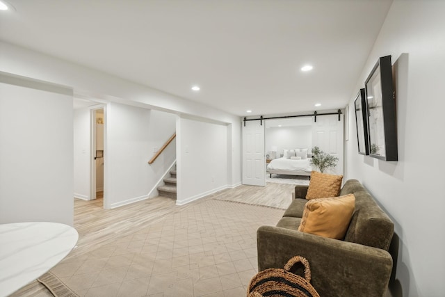 living room featuring light wood-type flooring and a barn door