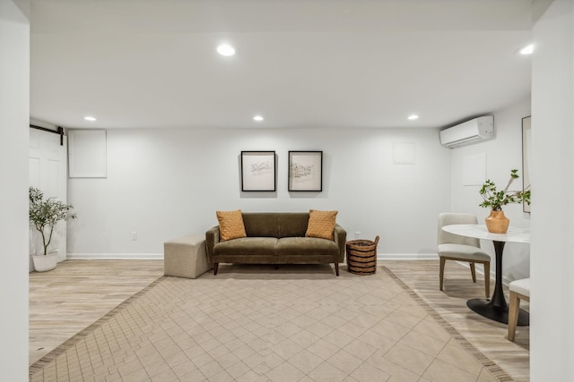 interior space with light hardwood / wood-style floors, a barn door, and an AC wall unit