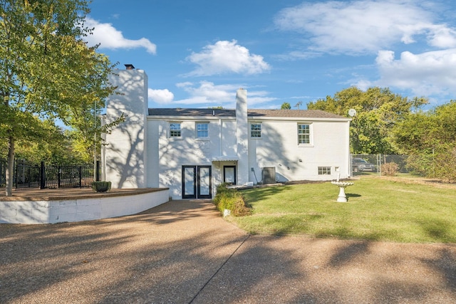 rear view of house with french doors, a yard, and central AC unit