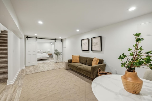 living room featuring a barn door and light hardwood / wood-style floors