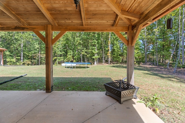 view of patio / terrace featuring a trampoline and an outdoor fire pit