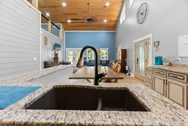 kitchen featuring french doors, sink, light stone counters, high vaulted ceiling, and wood ceiling