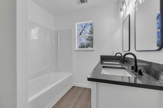 bathroom featuring hardwood / wood-style floors, vanity, and bathtub / shower combination