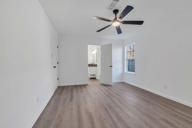 interior space with ensuite bath, ceiling fan, and light hardwood / wood-style flooring