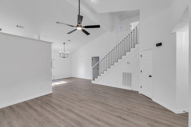 unfurnished living room featuring beam ceiling, high vaulted ceiling, ceiling fan with notable chandelier, and hardwood / wood-style flooring