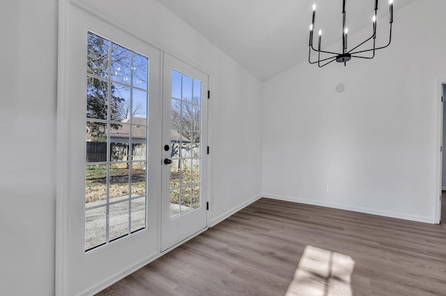 unfurnished dining area with hardwood / wood-style flooring and an inviting chandelier