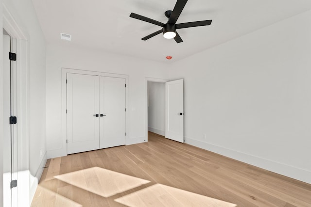 unfurnished bedroom featuring ceiling fan, a closet, and light hardwood / wood-style floors