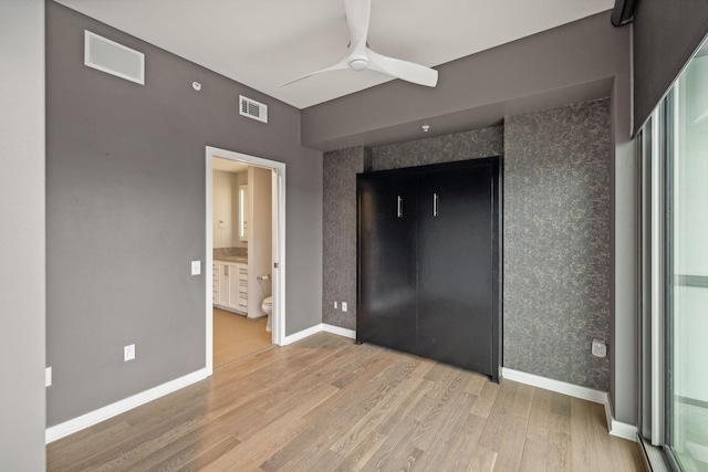 unfurnished bedroom with ensuite bath, ceiling fan, and light hardwood / wood-style floors