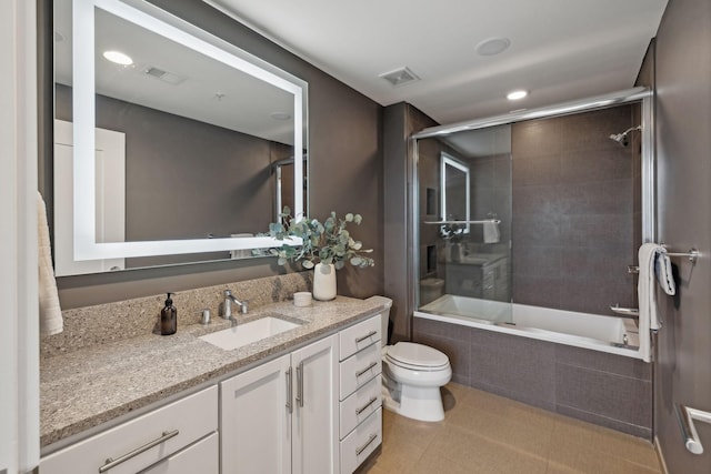 full bathroom with shower / bath combination with glass door, vanity, toilet, and tile patterned flooring