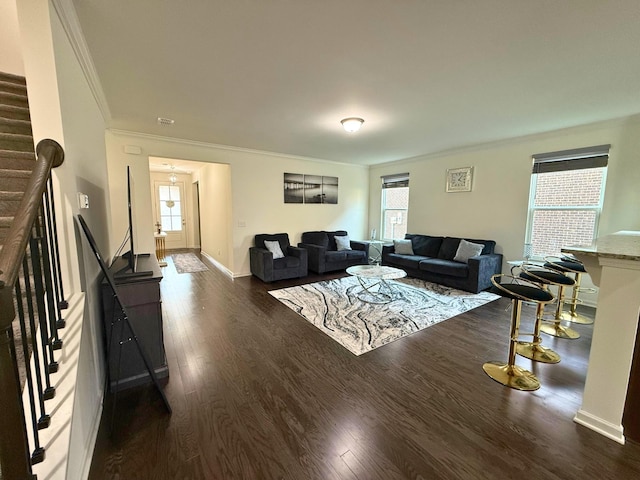 living room with visible vents, baseboards, stairway, dark wood finished floors, and crown molding