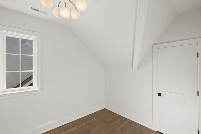 additional living space with dark hardwood / wood-style flooring, an inviting chandelier, and vaulted ceiling