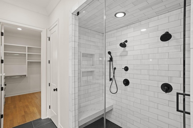 bathroom with tile patterned floors, tiled shower, and crown molding