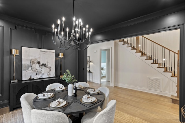 dining room featuring a chandelier, crown molding, and wood-type flooring