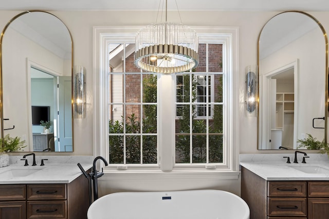 bathroom featuring a bathing tub, a notable chandelier, and vanity