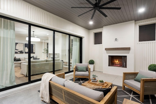 view of patio with an outdoor living space with a fireplace and ceiling fan