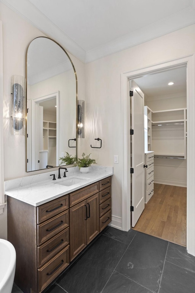 bathroom featuring crown molding, vanity, and wood-type flooring