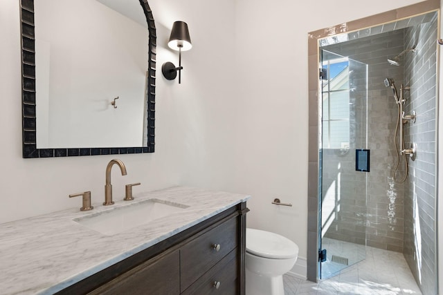 bathroom with tile patterned floors, vanity, toilet, and a shower with shower door