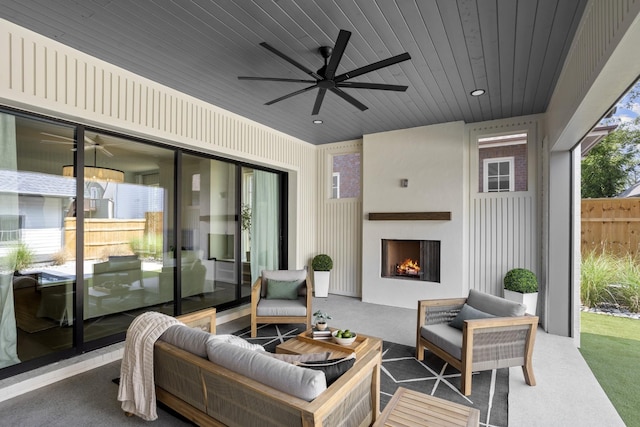 view of patio / terrace with ceiling fan and a fireplace