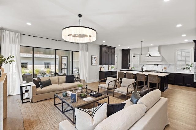 living room with light hardwood / wood-style floors and a chandelier