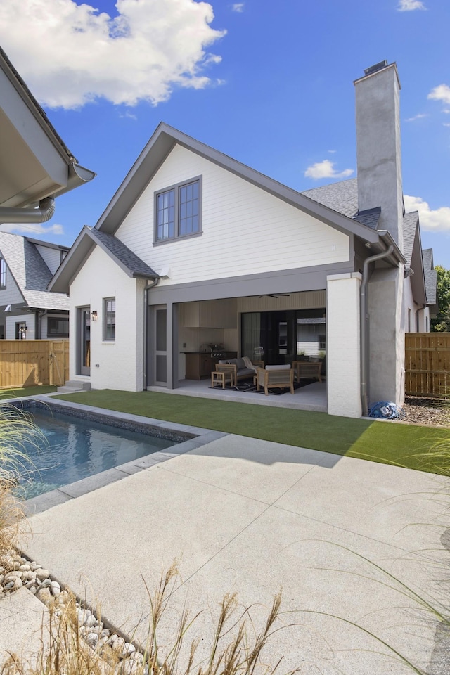 rear view of house with an outdoor living space, a fenced in pool, and a patio