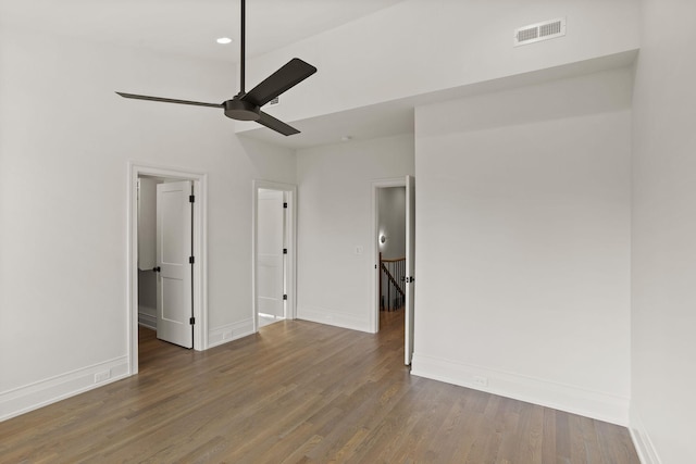 empty room with dark hardwood / wood-style flooring and ceiling fan