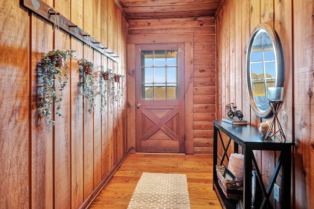 entryway featuring wooden ceiling and wooden walls