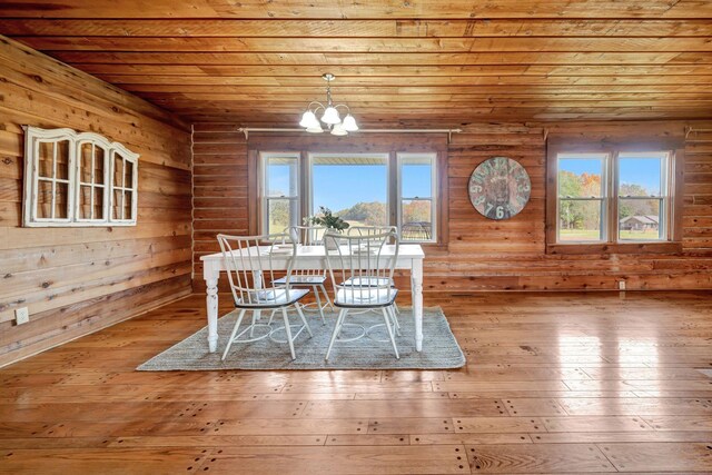 unfurnished dining area with light hardwood / wood-style floors, an inviting chandelier, and wooden ceiling