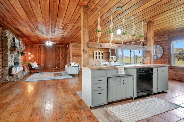 kitchen with black dishwasher, hanging light fixtures, wood walls, and wood ceiling