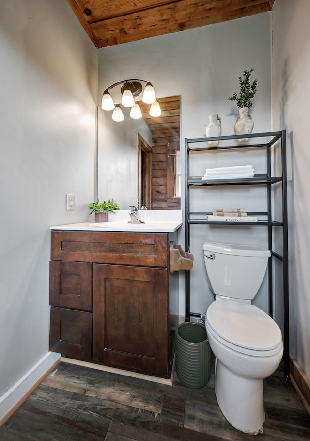 bathroom featuring wood-type flooring, vanity, toilet, and wooden ceiling