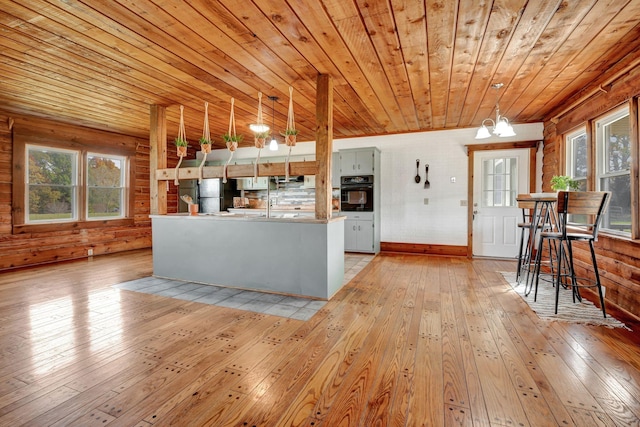 kitchen with wooden ceiling, hanging light fixtures, a notable chandelier, light hardwood / wood-style floors, and black appliances