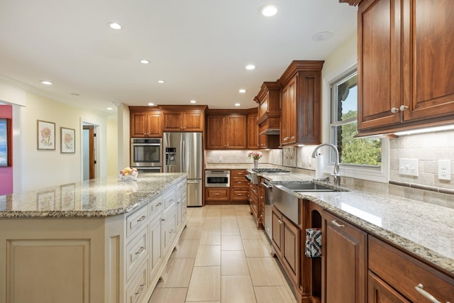 kitchen with backsplash, light stone countertops, a kitchen island, and stainless steel appliances