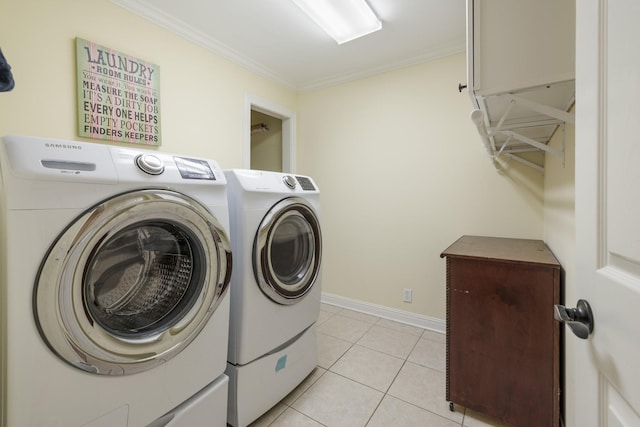 laundry area with washing machine and dryer, crown molding, and light tile patterned floors