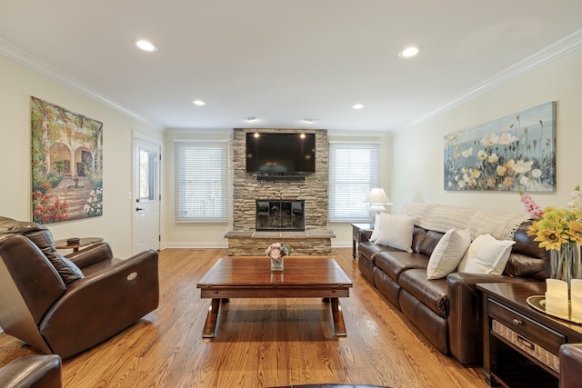 living room with crown molding, a fireplace, and light wood-type flooring