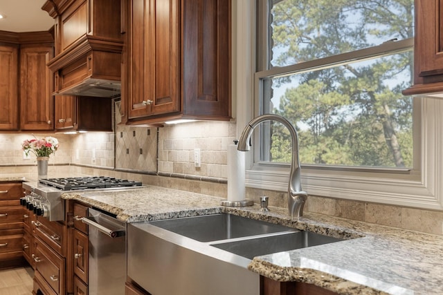 kitchen with backsplash, light stone countertops, sink, and stainless steel gas stovetop