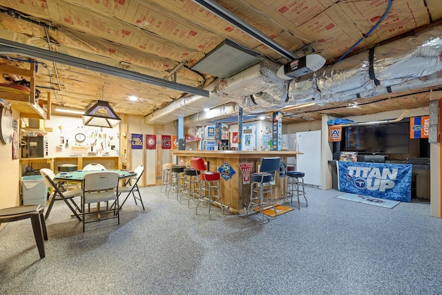 basement featuring bar and white fridge