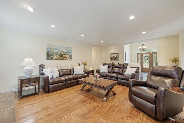 living room featuring light hardwood / wood-style floors, an inviting chandelier, and crown molding