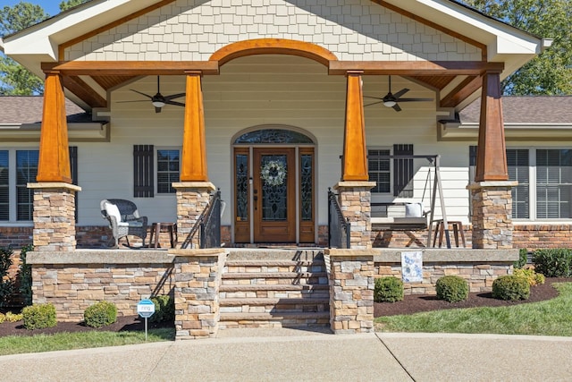 view of exterior entry with a porch and ceiling fan