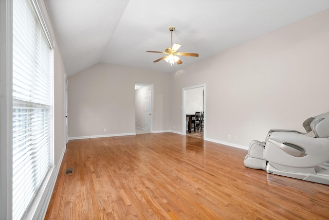 unfurnished living room with plenty of natural light, ceiling fan, light hardwood / wood-style flooring, and lofted ceiling