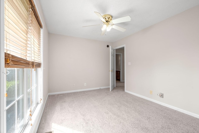 carpeted spare room featuring ceiling fan