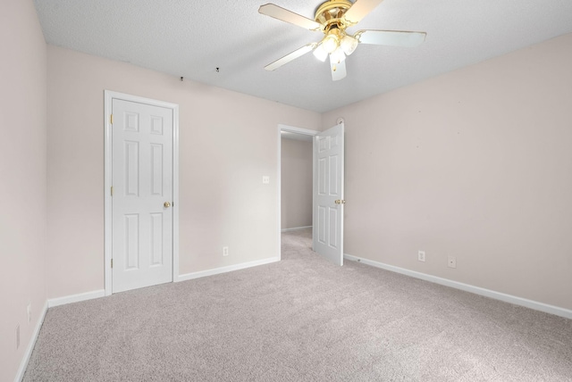 carpeted spare room with ceiling fan and a textured ceiling