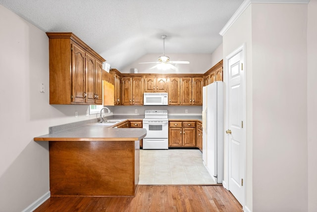 kitchen featuring kitchen peninsula, white appliances, ceiling fan, sink, and light hardwood / wood-style flooring