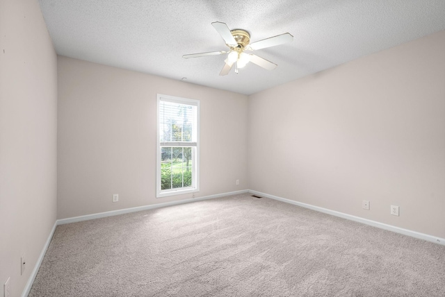 empty room with carpet flooring, a textured ceiling, and ceiling fan